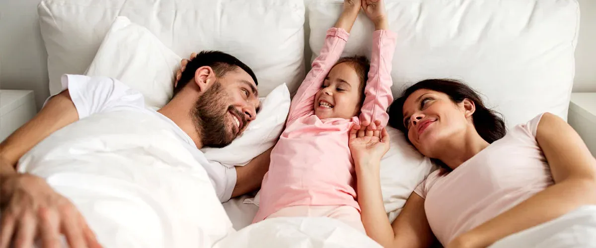 Family laying in bed bug free bed