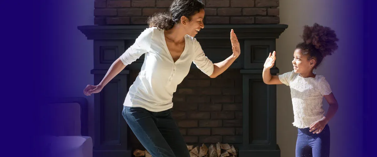 Mom and daughter high fiving in pest free living room